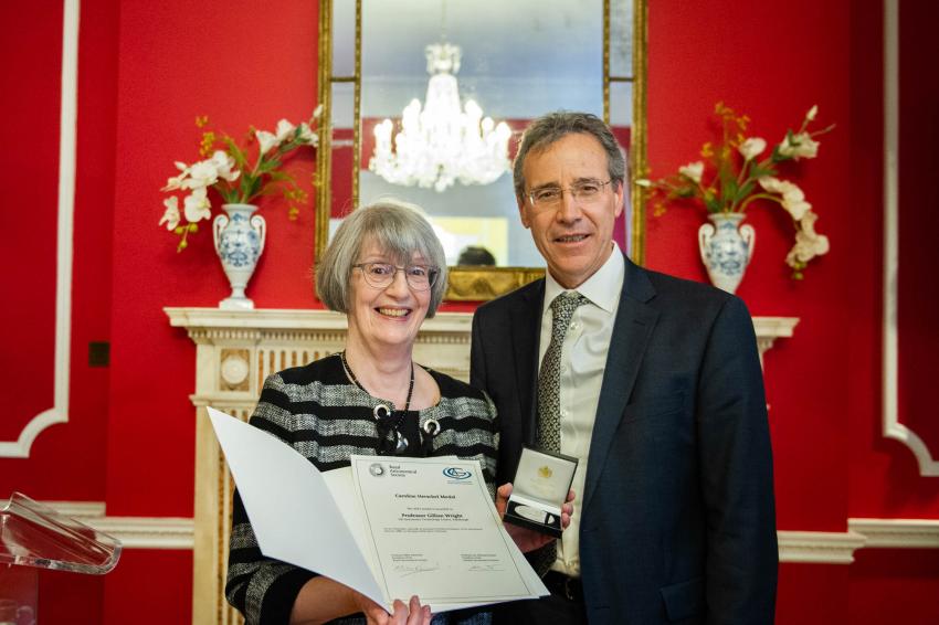 Ambassador Miguel Berger and Professor Gillian Wright stand side by side. Prof. Wright is holding a small box containing the medal and a certificate.