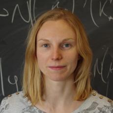 A photo of Rebecca in front of a blackboard