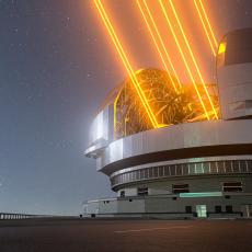 A very large ground-based telescope with observatory opened and using four laser guides.
