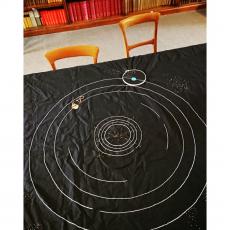Orbital paths of the planets in our solar system embroidered onto black cloth.