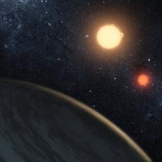 An artist's impression of the circumbinary planetary system Kepler 16-b. A planet is seen in the foreground, with 2 orange and yellow-hued stars in the background. Faint stars can be seen in the background.