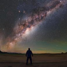 An image of the Milky Way with a person's silhouette in the foreground.