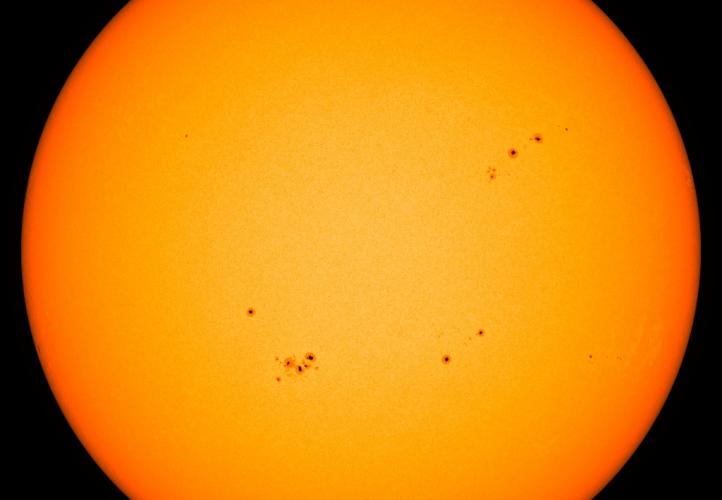 Image from the Solar Dynamics Observatory mission of the solar disk with multiple sunspots, which appear dark compared with their surroundings. Credit: HMI/SDO/NASA
