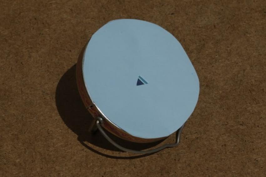 A picture of a mirror covered in paper with a 4-5mm hole in the centre. 