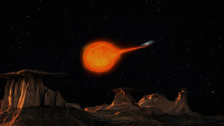 Image shows the surface of a rocky planet in the foreground in the lower half of the picture, a starry sky above with a red dwarf star. Material from the star is being pulled on to a small white dwarf star in a curving path.