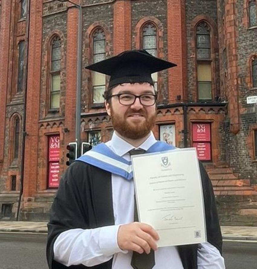 Portrait of Bradley Lewis holding his degree certificate